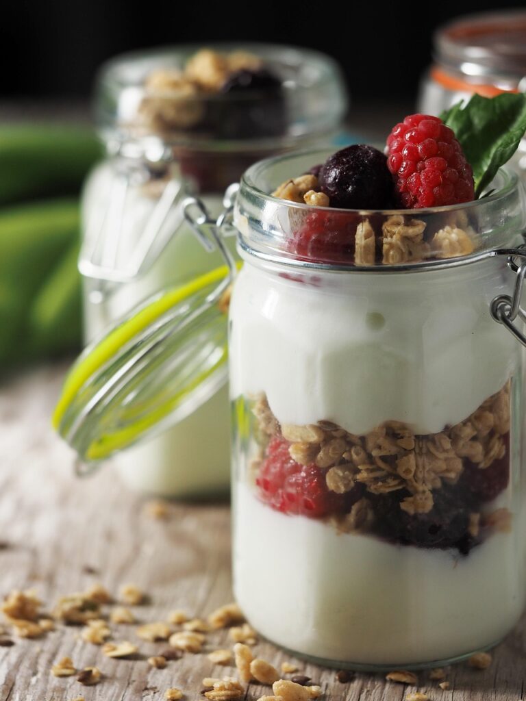American-style yogurt parfait layered with granola and mixed berries in a glass jar