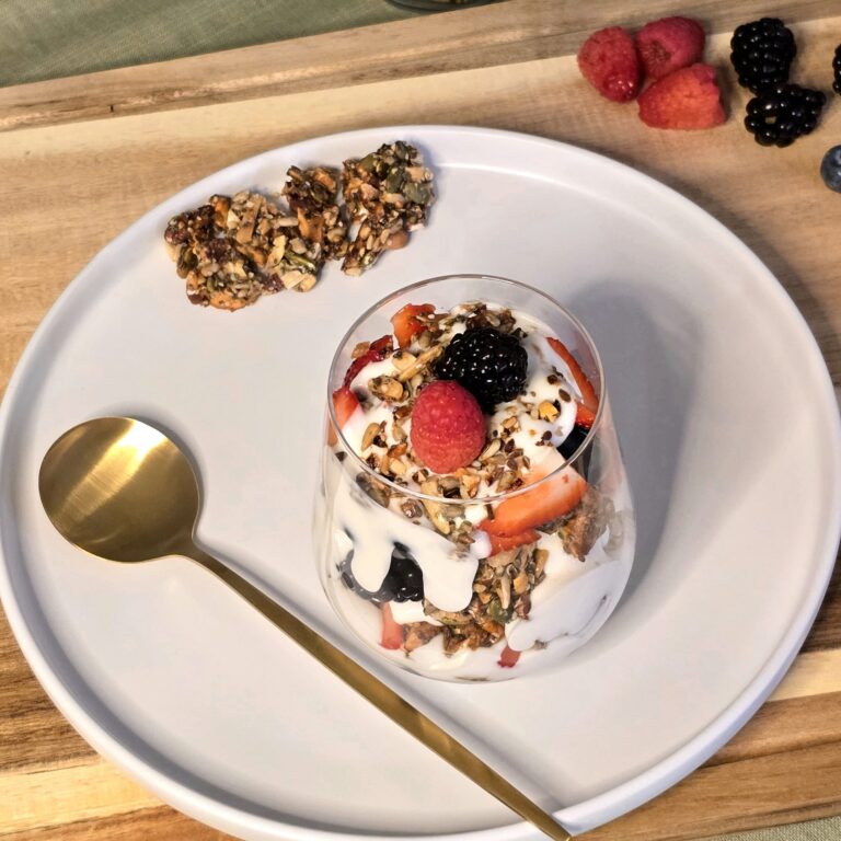 Seeded brittle and berry yogurt parfait layered with coconut yogurt and fresh berries