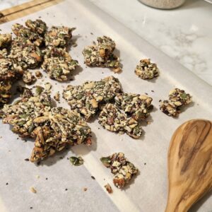 Maple-sweetened seeded brittle broken into crunchy pieces on parchment paper