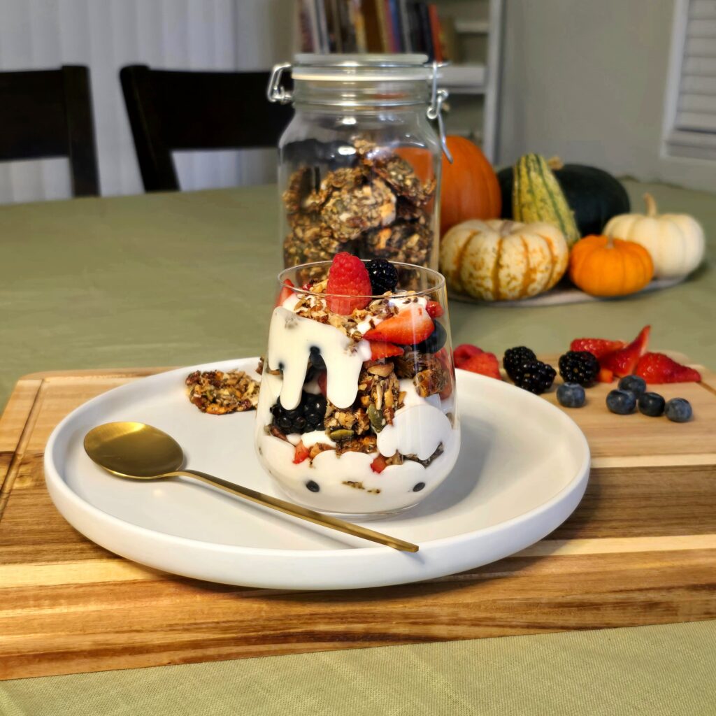 Yogurt parfait with seeded brittle and fresh berries on a wooden board